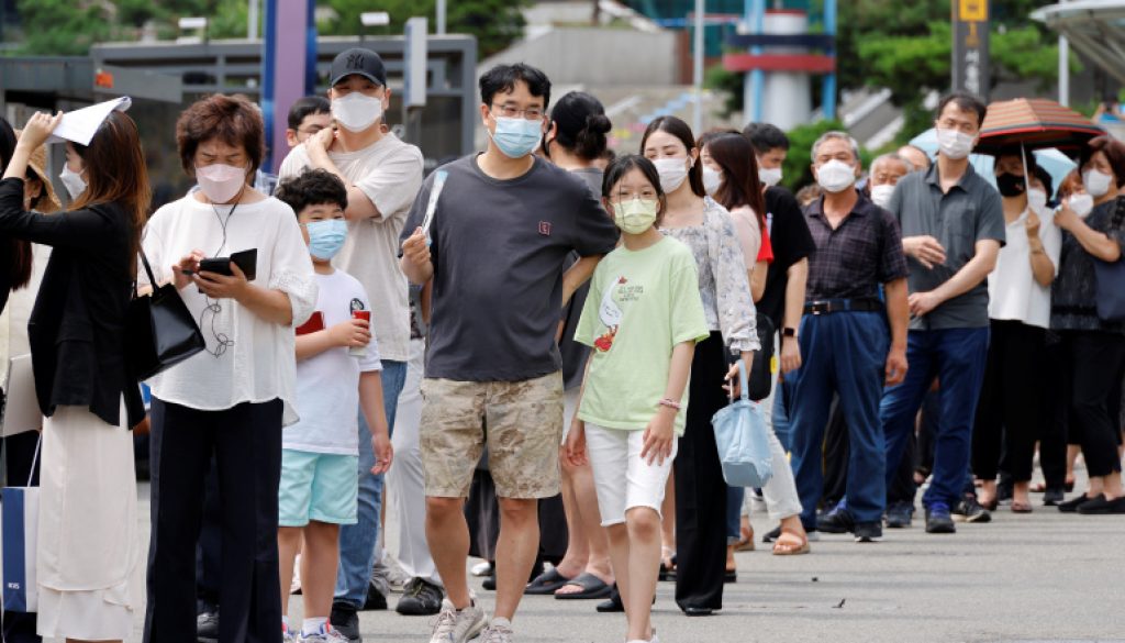 People wait in line for a coronavirus disease (COVID-19) test at a testing site which is temporarily set up at a railway station in Seoul